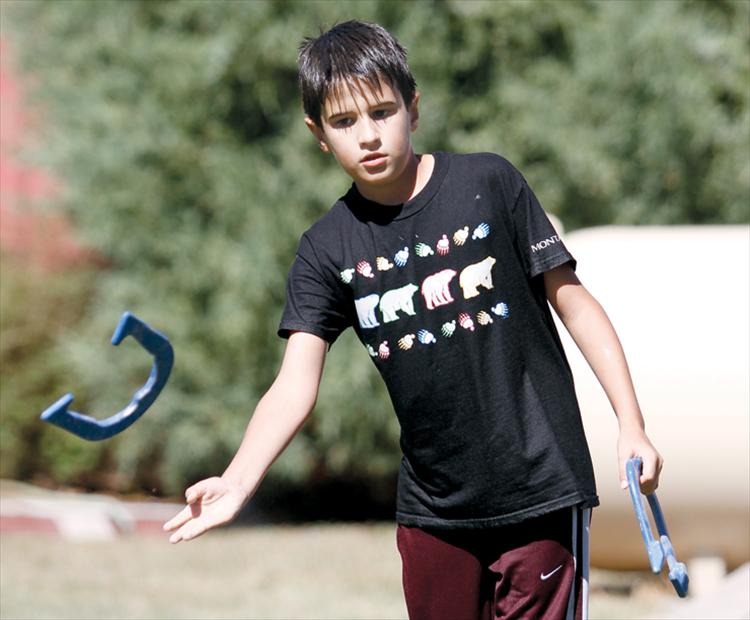 During a break from in Melon Days festivities, 10-year-old Reed Bocksnick of Ronan tosses a horseshoe with friends.