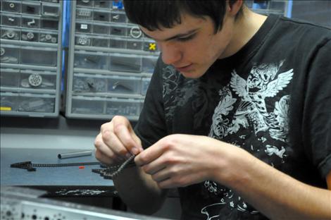 Cody Bear works with a tiny piece of the Ronan High School robotics team’s machine. 