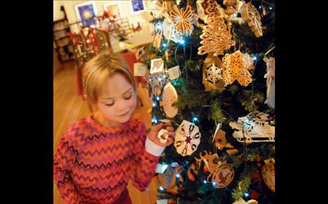 Mariah Haines, whose birthday is this week, looks at a tiny birdhouse ornament complete with a teeny tiny bird.