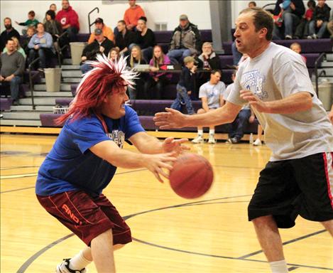 A wild-haired Kurt McPherson avoids a defensive move by a Farmer/Rancher player.