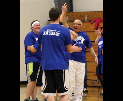 At left, Les Rice congratulates a teammate with an enthusiastic high-five.