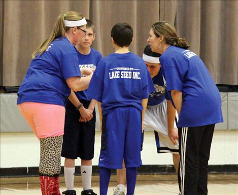 An eclectic mix of basketball players on the Mountain West Co-op team huddle up to create a strategy against the Farmers/Ranchers during the fundraising game.  