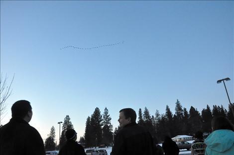 Congressman Steve Daines and President Robert DePoe III watch as as geese fly overhead. 