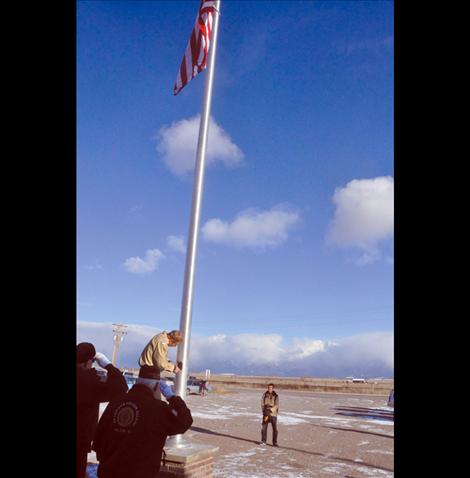 Members of the Veteran's Honor Guard help new Eagle Scout Ryan Fullerton raise the first flag to fly on a flagpole in front of the Charlo-Moiese Fire Department. The flagpole was erected as part of Fullerton’s Eagle Scout project.