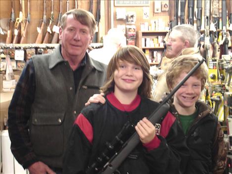 Presenting the 2013 22 Youth Shoot Rifle is Rob Shrider of Ronan Sports and Western. Winner Karen Thomas had her son Tim Thomas and Kendrew Deverouev accept the rifle from Rob.