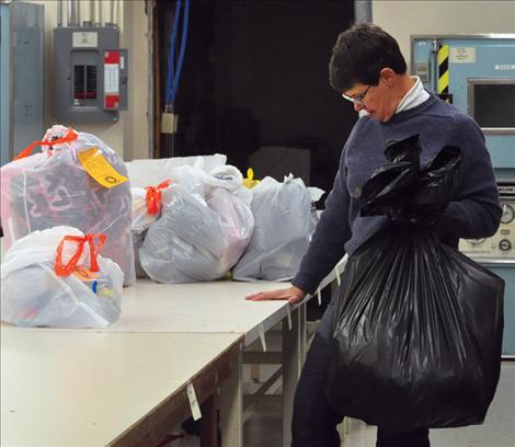 Checking a number, Share the Spirit volunteer Maggie Newman looks for the correct place for a child’s gift bag.