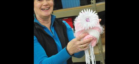 A stylish hat with a big flower and a matching scarf goes to some lucky little girl for Christmas. Community Church members made 200 sets of hats and scarves for Share the Spirit 