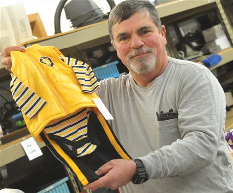 Share the Spirit Volunteer Emmett May picks out a baby boy’s outfit as he packages gifts for children ages birth to 12 years old.