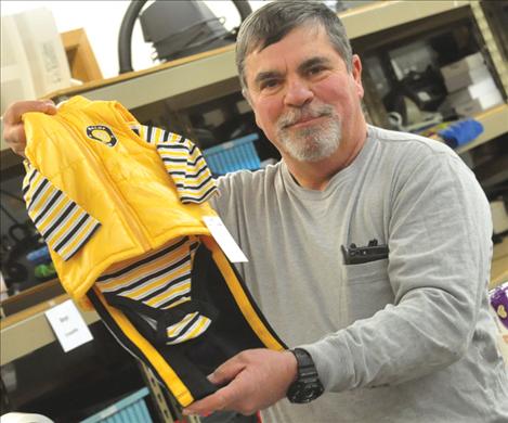 Share the Spirit Volunteer Emmett May picks out  a baby boy’s outfit as he packages gifts for children ages birth to 12 years old.  