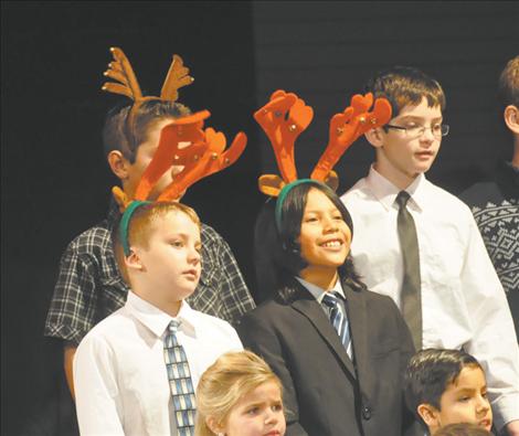 Students shake their antlers to make bells jingle in the K. William Harvey Elementary School Carol-along. 