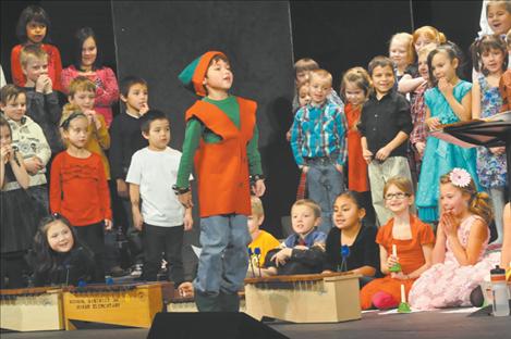 Gabriel Brown plays Jingle, “the Happy Bell” as Mrs. Lozar’s class provides instrumentation in the K. William Harvey Elementary School’s Christmas Carol-Along. 