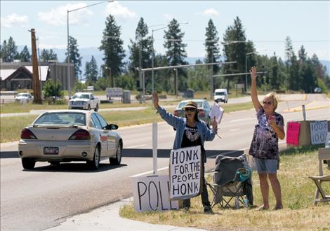 Members of the People’s Voice, a group calling for the Confederated Salish and Kootenai Tribes to pay 100 percent of recently won settlement money to  individual tribal members, wave to passers-by in Pablo near CSKT  headquarters earlier this month.
