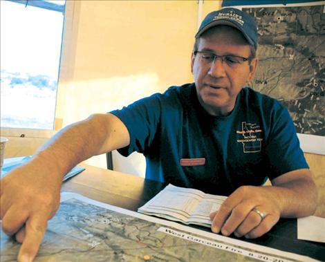 Randy McKenzie, operatons chief, points out the outline of the West Garcon fire.