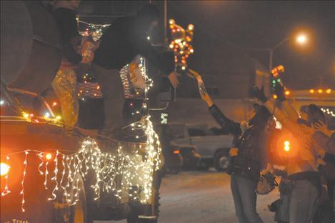 Tickets are handed up to the Holiday Treasures hopper during the Parade of Lights. 