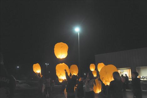 A crowd of people light lanterns before they are sent to the heavens bearing messages for loved ones. 