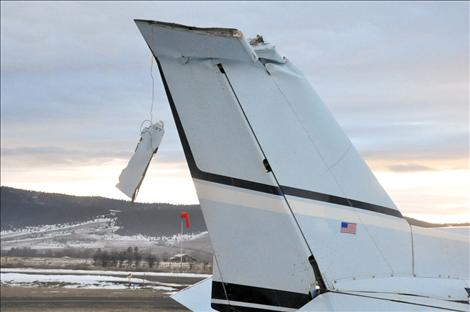 A Cessna 152 that crashed at the St. Ignatius airport on Christmas Eve sits on the runway, awaiting inspection by Federal Aviation Administration investigators.