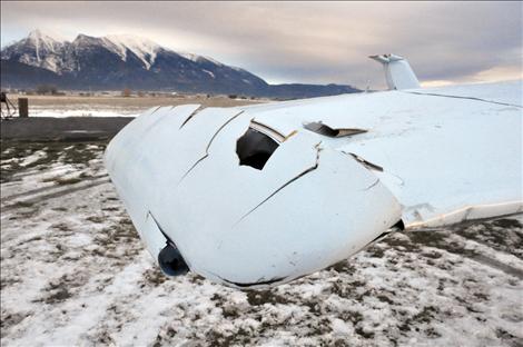 A Cessna 152 that crashed at the St. Ignatius airport on Christmas Eve sits on the runway, awaiting inspection by Federal Aviation Administration investigators.