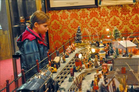 Elexa Monroy, 7, watches Preston Miller’s toy train display steam down the track at Four Winds Trading Post.