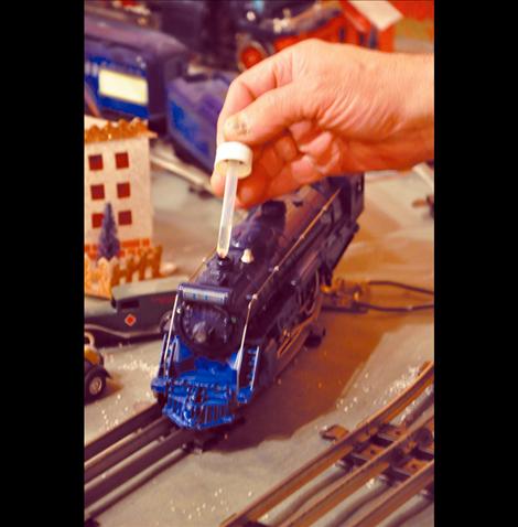 Conductor Preston Miller adds a drop of oil to the Lionel engine. 