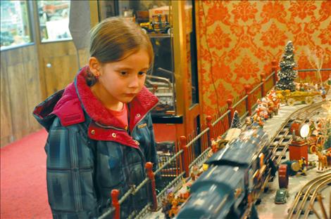 Elexa Monroy, 7, watches Preston Miller’s toy train display steam down the track at Four Winds Trading Post.