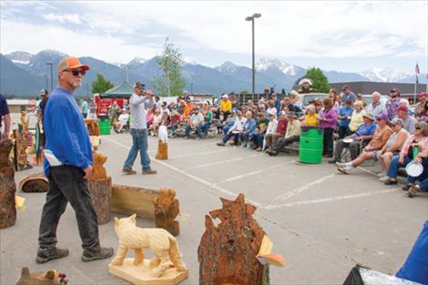 Chainsaw Carving Rendezvous spectators bid on items carved during the event at Sunday’s auction and peruse other works of art for sale brought by contest carvers.