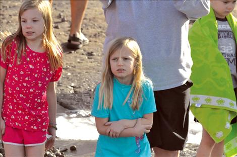 Lauren Collinge shivers while waiting at Riverside Park for the clock to strike 1 p.m. so she can charge into Flathead Lake. 