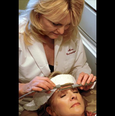 Marie Noble gives Marilyn Jette a microcurrent facial at Reflections Salon in Ronan.
