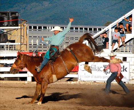 Saddle bronc rider Marty Hebb exhibits classic saddle bronc style as he spurs a big sorrel bronc.