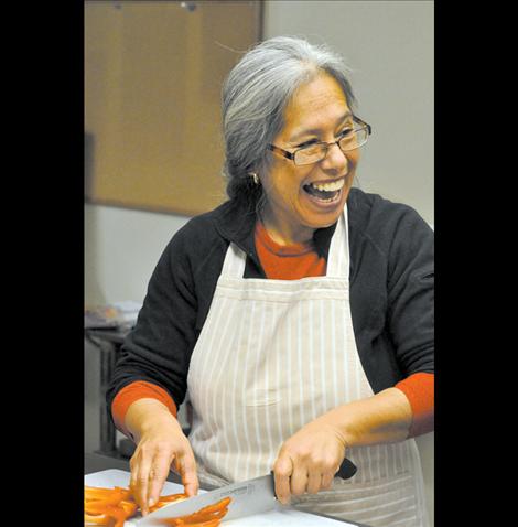 Ofelia Folsom laughs as she chops peppers early in the morning at La Cocina De Esperanza.