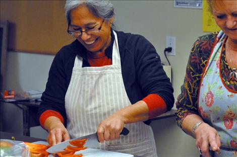 Ofelia Folsom laughs as she chops peppers early in the morning at La Cocina De Esperanza.