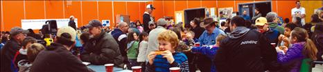 Dads and children pack the lunchroom at Linderman Elementary School.