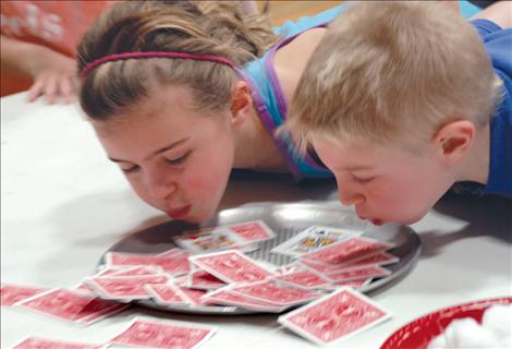 Kids blow air to move cards during game time in Linderman gym at the first Watch D.O.G.S. meeting.