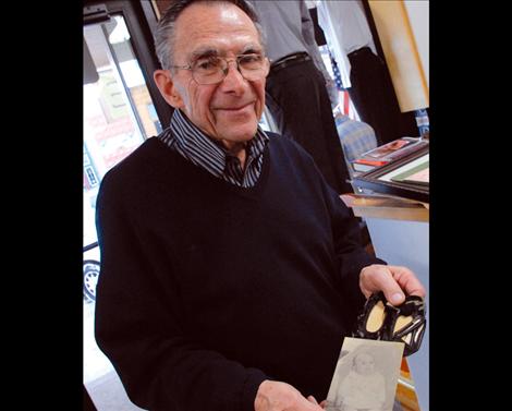 Jim Duford hold shoes he wore when he was an infant and his baby picture. His mother wrote poetry and penned a poem about his baby shoes. 