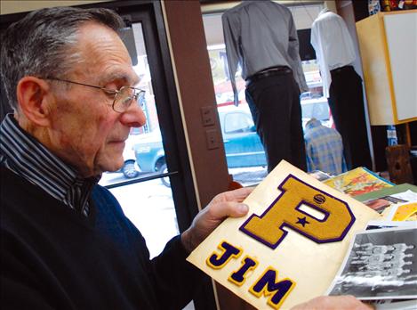 Jim Duford looks over a scrapbook filled with high school memorabilia.