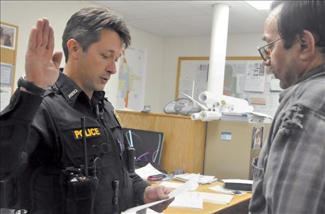 Mayor Kim Aipperspach, right, swears in Timothy Case as a Ronan police officer.  