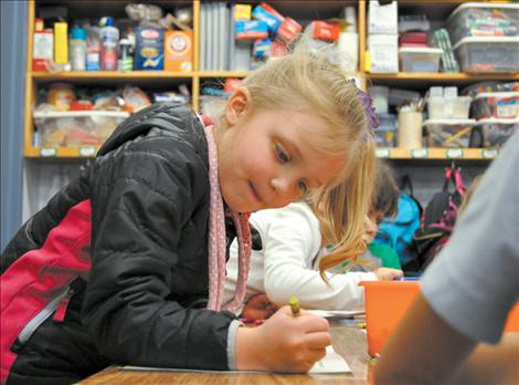 Olivia Cheff colors a rainbow that depicts what she thinks will make a more peaceful world. 