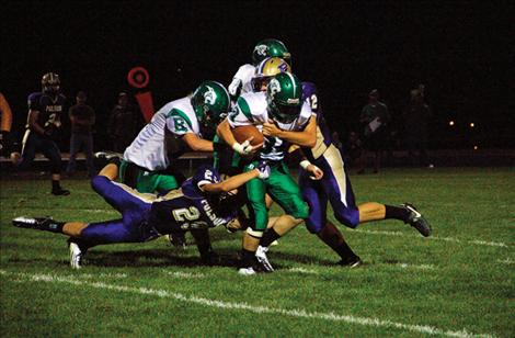 Polson Pirates Cedrick Smith, left, and Brady Hislop take down a Belgrade player during last Friday’s home game. 