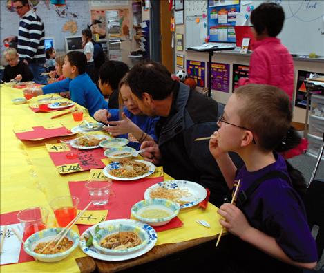 Fourth graders enjoy a Chinese lunch as Tyneesha Brown, center, explains something to her dad, Cody Brown.