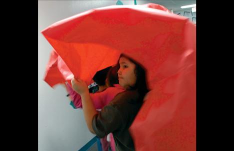 Underneath that dragon’s colorful head and long red body are Mrs. Lozar’s fourth grade class moving the dragon.