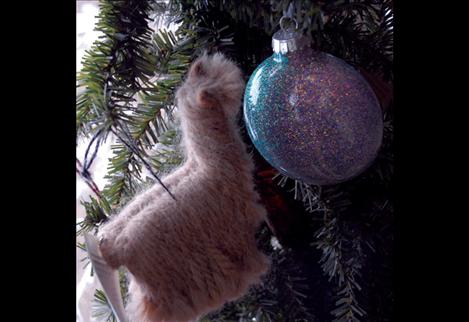 Miniature alpaca Christmas ornaments adorn a tree.