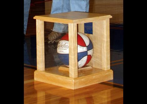 A glass-encased basketball from his early years of coaching was presented to Les Rice.