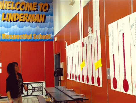 Classes at Linderman Elementary School collect Box Tops for Education, and Sheri Todd, school attendance secretary, looks at the graphs showing the numbers. 