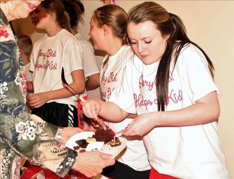 Shaylee Perry helps serve chocolate treats to raise money for local kids’ programs.