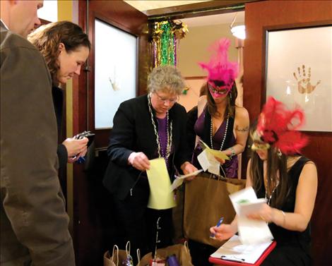 Boys and Girls Club board members and volunteers check receipts to disperse winnings to silent auction winners.