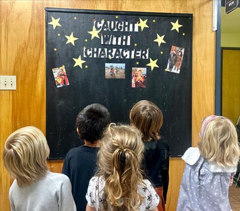 Cherry Valley students look at photos of their peers on the Caught with Character board on the wall at the school.