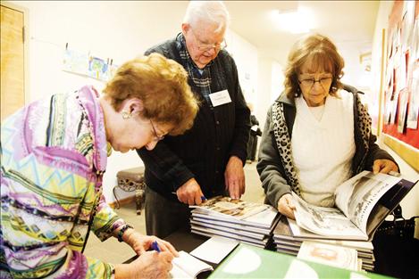 Author Paul Fugleberg sells a copy of “Among Other Things” as customers browse.