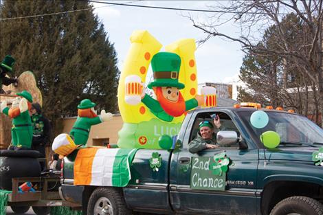 A passenger on the Second Chance Float throws candy to eager children. Second Chance won the Biggest Shamrocks category
