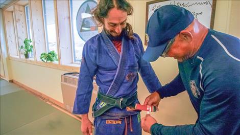 Egan Inoue promotes Coach Owen Garcia with two stripes onto his black belt.
