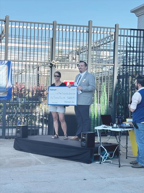 Polson Walmart Manager Dave Tolley presents a $2000 Spark Good Local Grant award to Ninepipes Museum Board Member Laura Sharp.