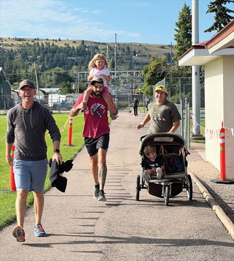 Participants Chris Clave and the Andrade family take laps around the Linderman track. 